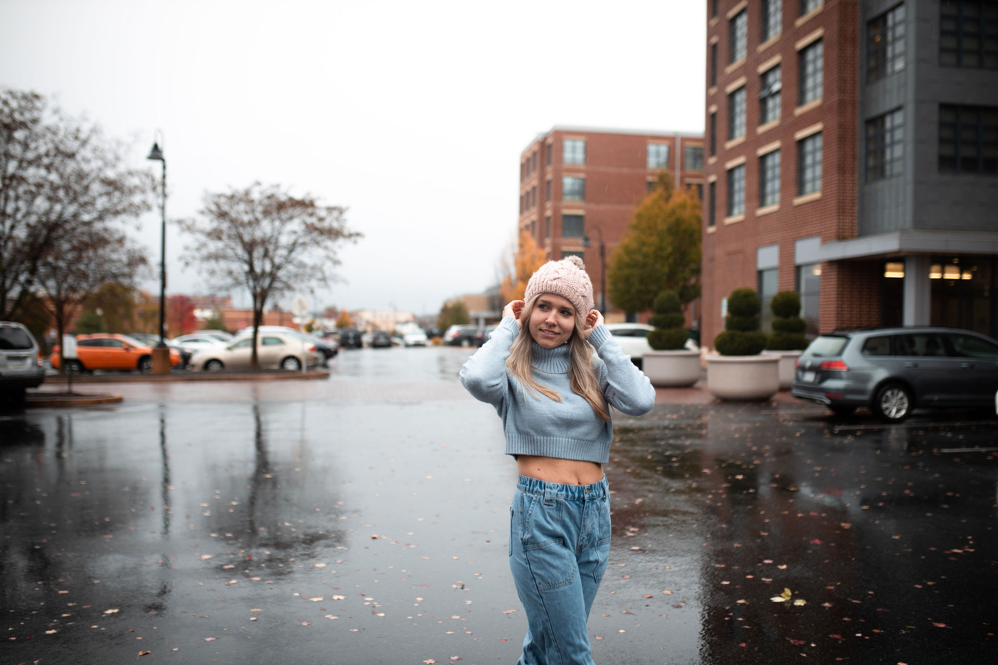 A portrait of a woman in a sweater walking in the rain in Lancaster, PA